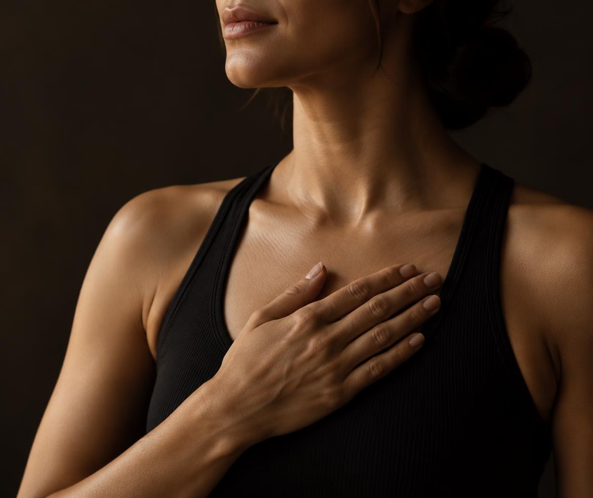 A woman resting her hand over her chest